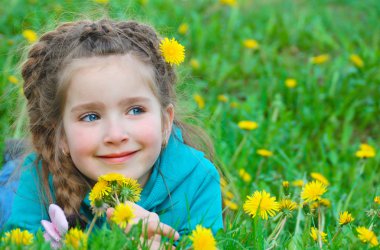 küçük kız dandelions sahada düşünceli yalan asit görünüyor