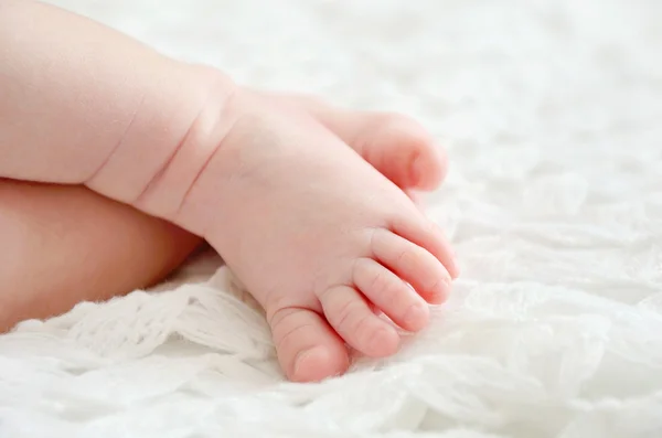 Petits orteils de bébé sur enveloppe tricotée blanche — Photo