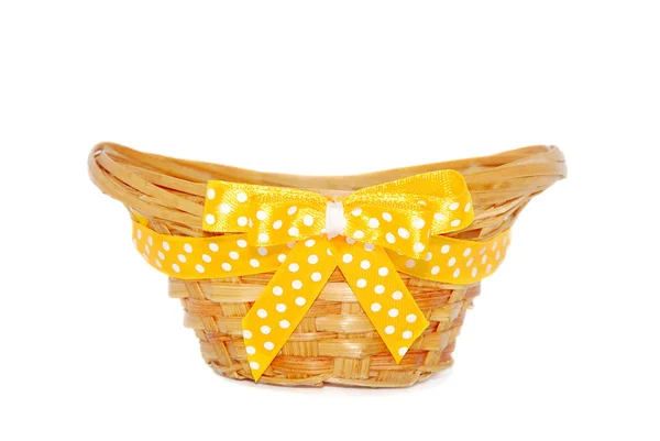 Empty straw basket with a yellow ribbon and a bow — Stock Photo, Image