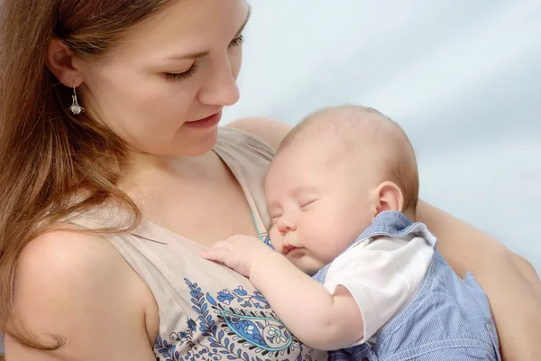 Porträt einer jungen Mutter, die ihr Baby hält lizenzfreie Stockfotos