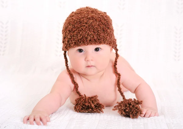 Niedliches Baby mit lustigem braunem Hut lizenzfreie Stockbilder