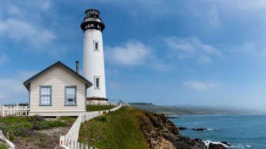Pigeon Point Deniz Feneri turizmi ve uçurum kıyısındaki tarihi yapı. Kaliforniya, Big Sur 'da açık mavi yaz gökyüzü