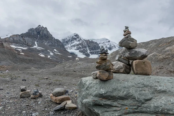 Stone Inukshuk Native landmark and beautiful Canadian landscapes at the Columbia Icefields Glacier in Jasper National Park rocky mountain peaks background