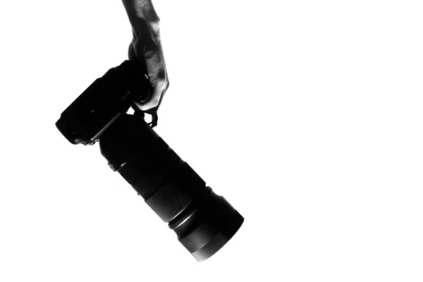 プロの写真家の手は 白の背景に隔離されたデジタル一般的なカメラ本体と望遠レンズのシルエットを保持 芸術表現 創作趣味としての写真 — ストック写真