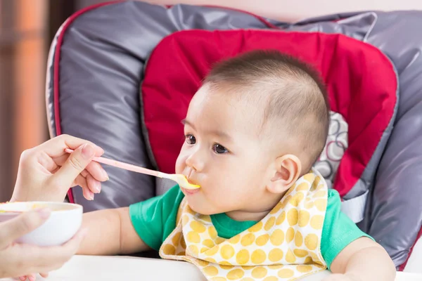 Mutter füttert ihr Kind mit Babynahrung — Stockfoto