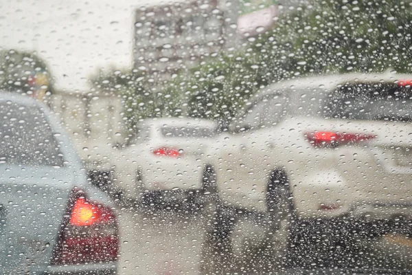 Conduce en un día lluvioso, la lluvia cae sobre el coche parabrisas — Foto de Stock