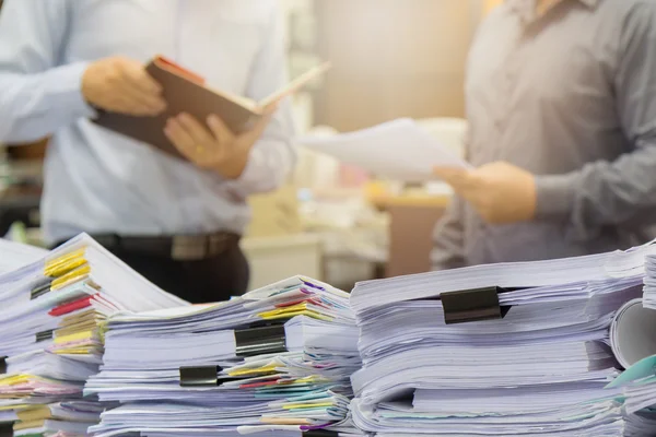 Montón de documentos sin terminar en el escritorio de la oficina con fondo de hombre de negocios — Foto de Stock