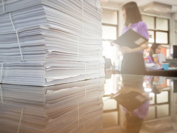 Stapel van onvoltooide documenten op Bureau met zakenvrouw achtergrond — Stockfoto