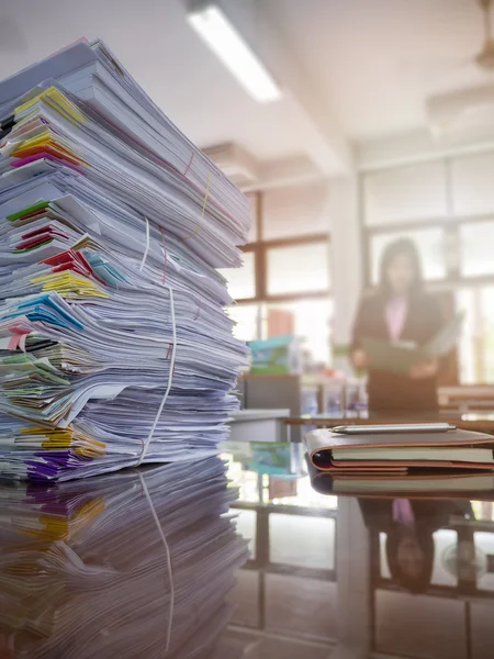 Montón de documentos sin terminar en el escritorio de la oficina con fondo de mujer de negocios —  Fotos de Stock
