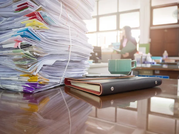 Gramada de documente neterminate pe biroul de birou cu fundal femeie de afaceri — Fotografie, imagine de stoc