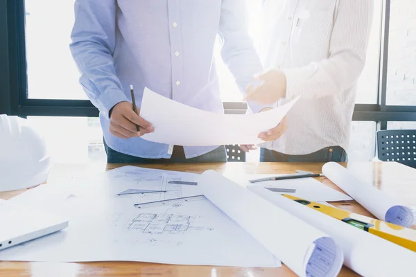 Arquitectos trabajando con planos en la oficina — Foto de Stock