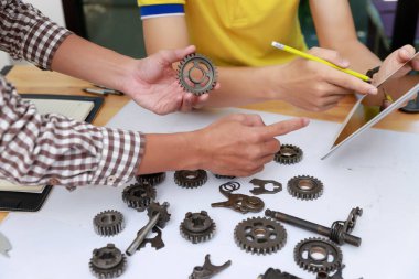 Engineer discussing and designing about mechanical gear parts in office.