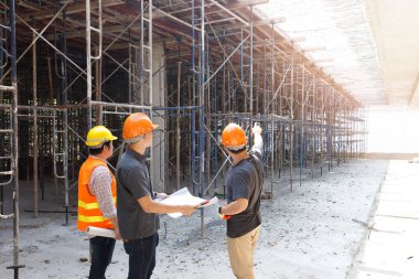 İnşaat mühendisi ve mimar inşaat alanında mavi baskı ile çalışma kavramı