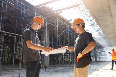İnşaat mühendisi ve mimar inşaat alanında mavi baskı ile çalışma kavramı