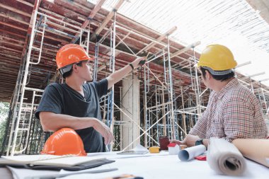 İnşaat mühendisi ve mimar inşaat alanında mavi baskı ile çalışma kavramı