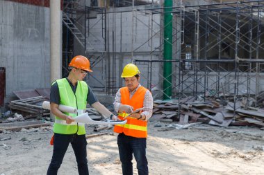 İnşaat mühendisi ve mimar inşaat alanında mavi baskı ile çalışma kavramı