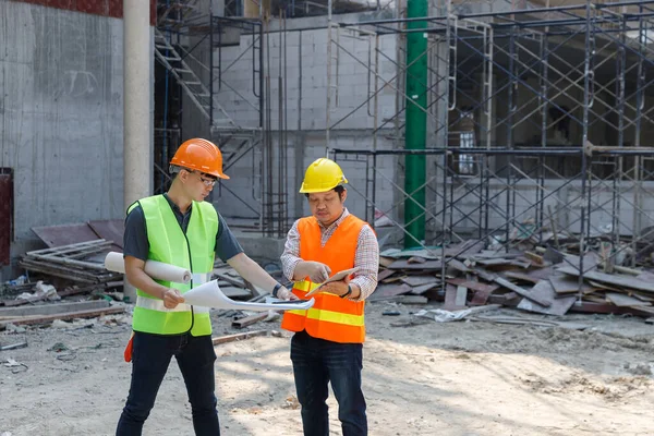 İnşaat mühendisi ve mimar inşaat alanında mavi baskı ile çalışma kavramı