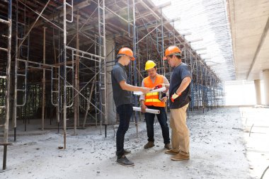 İnşaat mühendisi ve mimar inşaat alanında mavi baskı ile çalışma kavramı