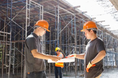 İnşaat mühendisi ve mimar inşaat alanında mavi baskı ile çalışma kavramı