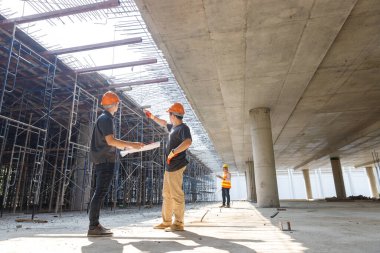 İnşaat mühendisi ve mimar inşaat alanında mavi baskı ile çalışma kavramı