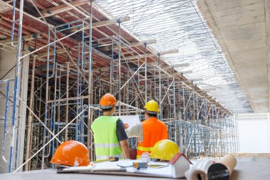 İnşaat mühendisi ve mimar inşaat alanında mavi baskı ile çalışma kavramı