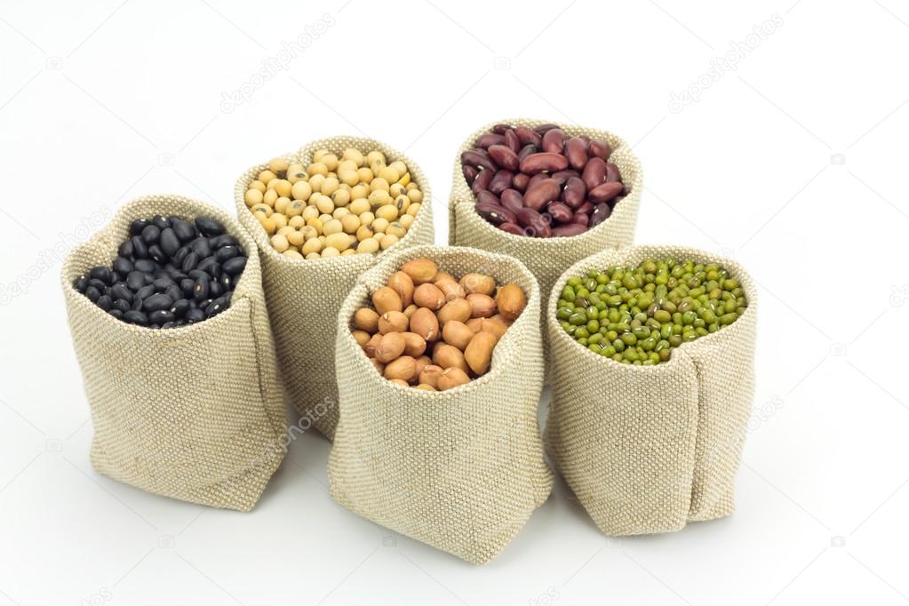Different kinds of beans in sacks bag isolated on white background
