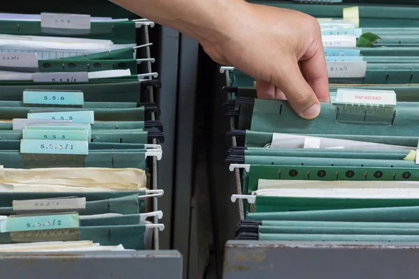 Hand holding top secret file in filing cabinet — Stock Photo, Image