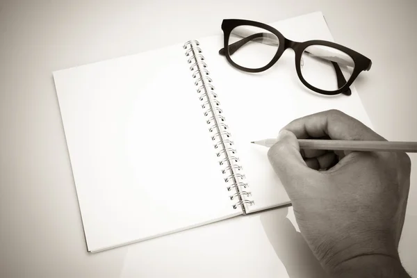 ノートブックと眼メガネ、ヴィンテージ効果で鉛筆を持つ手 — ストック写真