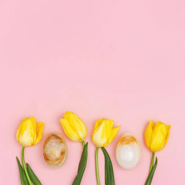 Dekoratív húsvéti tojás és tavaszi sárga friss virágok tulipán rózsaszín háttér másolási hely. Boldog húsvéti kártyát!. — Stock Fotó