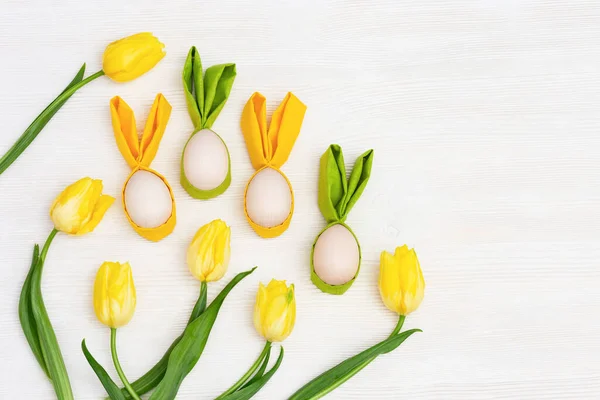 Dekoratív húsvéti tojás tavasz sárga friss virágok tulipán fehér fa háttér — Stock Fotó