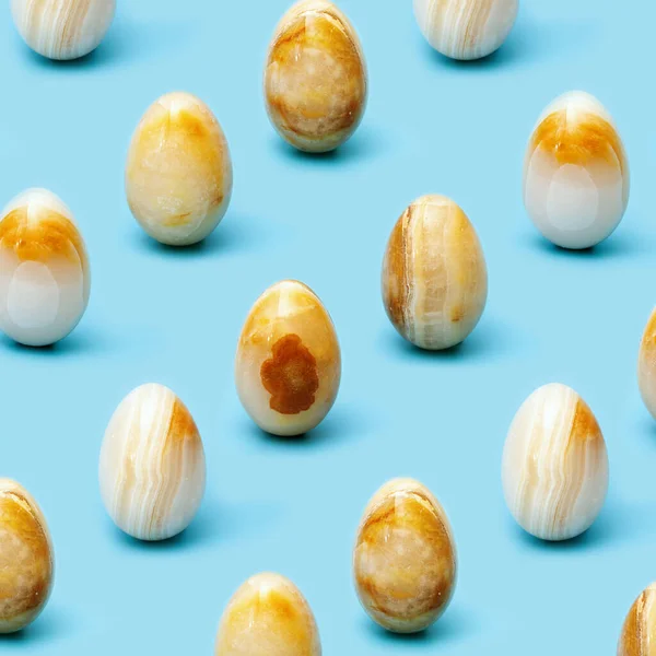 Patroon van paaseieren van Natuurlijke edelsteen onyx op blauw papier. Trendy voorjaarsvakantie arrangement. — Stockfoto