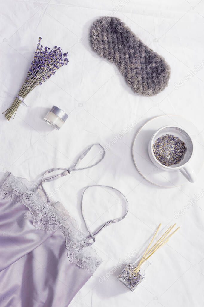 Healthy night sleep concept, pajamas, sleep mask, cup of lavender tea, aromas for better falling asleep, pillow