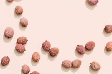 Pastel bej arka planda taze Lychee meyvesi. En az meyve ve yaz konsepti.