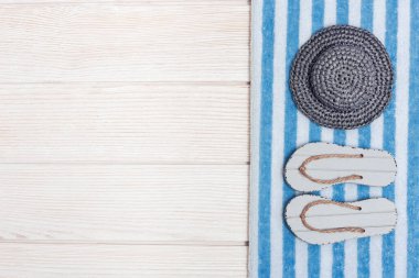 Yaz tatili için deniz, yaz ayakkabıları terlikler, pamuk havlu, güneşten kalma gri şapka.