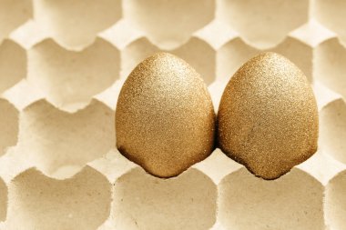 Kartondan yumurta tepsisinde iki tane süslü Paskalya yumurtası. Mutlu Paskalyalar, boyalı tavuk yumurtalarıyla birlikte yaratıcı bahar görüntüsü..