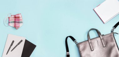 Banner wirt gri deri sırt çantası, içinde okul malzemeleri, yüz maskesi, defterler, fotokopi alanı olan kağıt kaplama kalemler. Okul konseptine geri dönelim. Yaklaş, boşluğu kopyala, düzleştir.