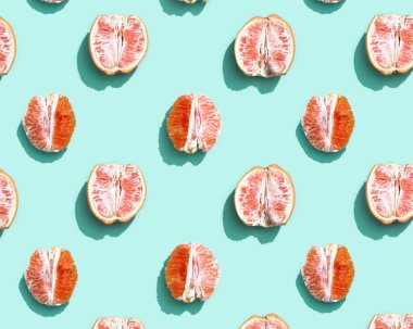 Turuncu kabuksuz kırmızı desen ya da parlak turkuaz arka planda greyfurt. En az yaz meyvesi konsepti.