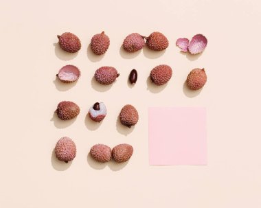 Pastel bej arka planda taze Lychee meyvesi deseni. Minimum meyve ve yaz konsepti. Üst görünüm ve gün ışığı.