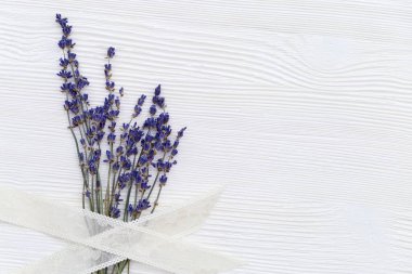 Beyaz ahşap arka planda örülmüş lavanta çiçekleri ve fotokopi alanı. Yukarıdan bak. Lavanta çiçekli kenar.