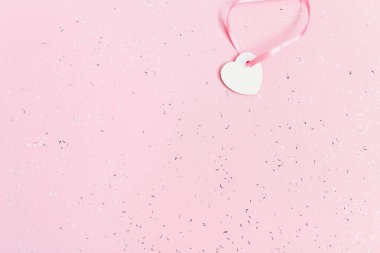 Pembe arka planda, pullarla kaplı beyaz, küçük bir kalp. Tatil konsepti. Tebrik kartı. Alışveriş satışı.