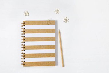 Metal klipsli okul defteri. İlkbaharda kapalı defter ve hafif çalışma alanında ahşap kalem. Okul konseptine geri dönelim. Üst görünüm.