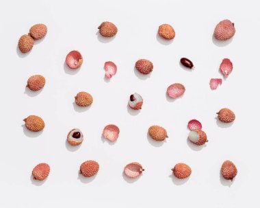 Beyaz arka planda taze Lychee meyvesi. Minimum meyve ve yaz konsepti. Üst görünüm ve güneş ışığı