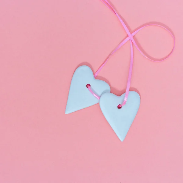 恋愛概念が好き ピンクの紙のパステルカラーにホワイトのハートとピンクのリボンが2つ 心が繋がった バレンタインデーの背景 ミニマルスタイル — ストック写真