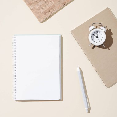 Boş sayfaları ve beyaz saati olan açık defterli sonbahar çalışma alanı. Sonbahar zamanı ve ruh hali konsepti. Doğal sonbahar bitkisel gelinciğiyle yatıyordu..