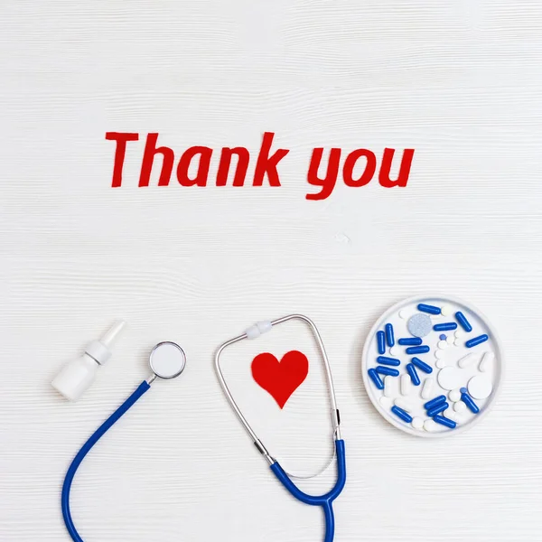 Healthcare and medical concept. Medical things on table red heart and text thank you on white wooden background with copy space. National Nurses Day. Top view.