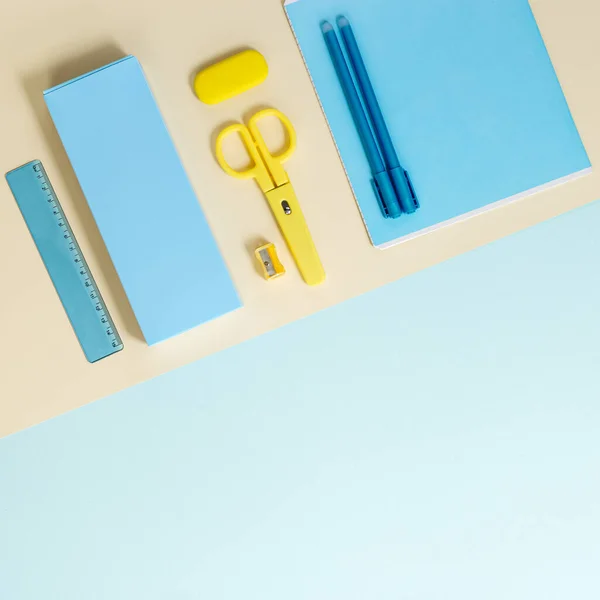 文房具や学校用品 ノート 鉛筆ケース はさみ 着色された背景 青と黄色のパステルカラーの消しゴムのフラットレイアウト 学校のコンセプトに戻る トップ表示 — ストック写真