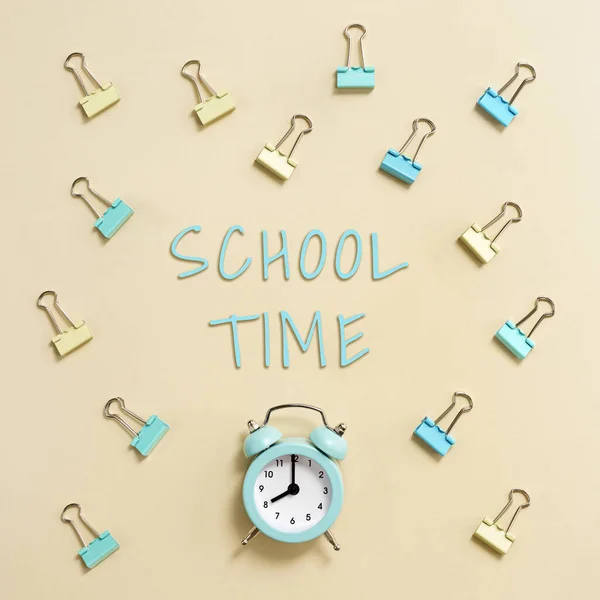 目覚まし時計リングと午前8時 時間の学校の概念に移動することを示しています カラフルな黄色のパステルの背景に時計や紙クリップと創造的なフラットレイ — ストック写真