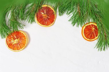 Kozalaklı dallar ve kurutulmuş portakallar. Noel arkaplanı. Çam dalları çerçevesi. Üst Manzara. Boşluğu kopyala.