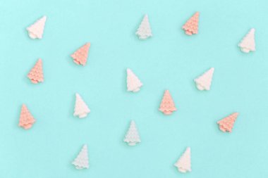 Noel ağacı şeklinde küçük tatlı şekerlemeler. Yeni yıl veya Noel için renkli şeker yaratıcı. Pastel renkler - nane ve pembe.