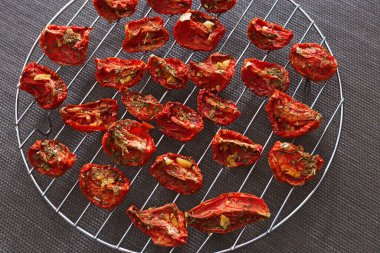 Kırmızı domates dilimleri güneşte kurutulmuş metal ızgarada dizilmiş. Uzayı kopyala Kapatın. Çok sağlıklı vejetaryen yemekleri..